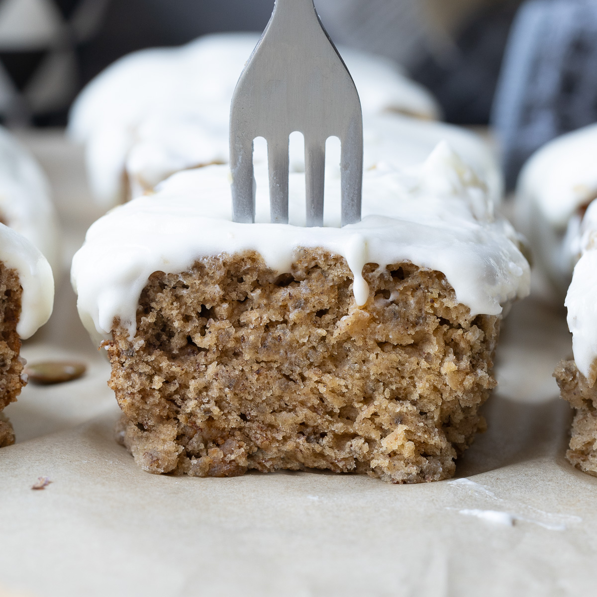 Close up of a gluten-free banana cake with cream cheese frosting.